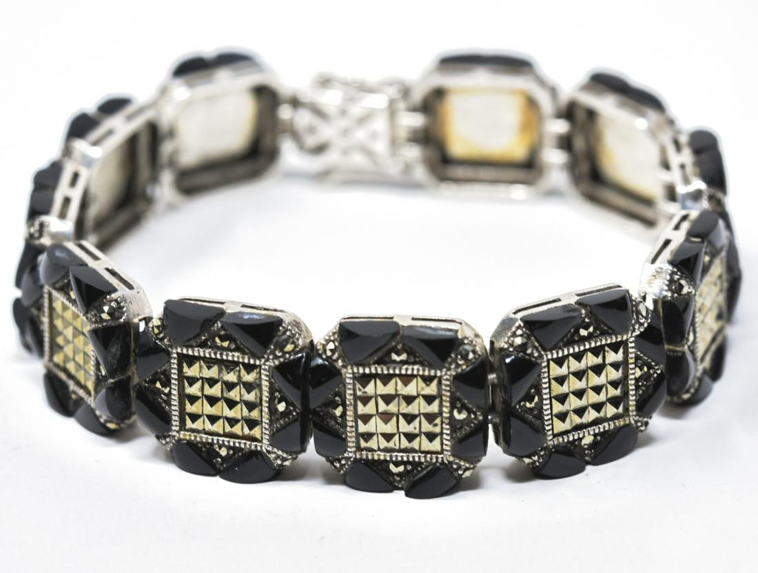 Art Deco Sterling Sterling Onyx Marcasite Bracelet: Art Deco Sterling Sterling Onyx Marcasite Bracelet. Panel bracelet. Measures 7.5 inches in length. Has a safety on either side of clasp.