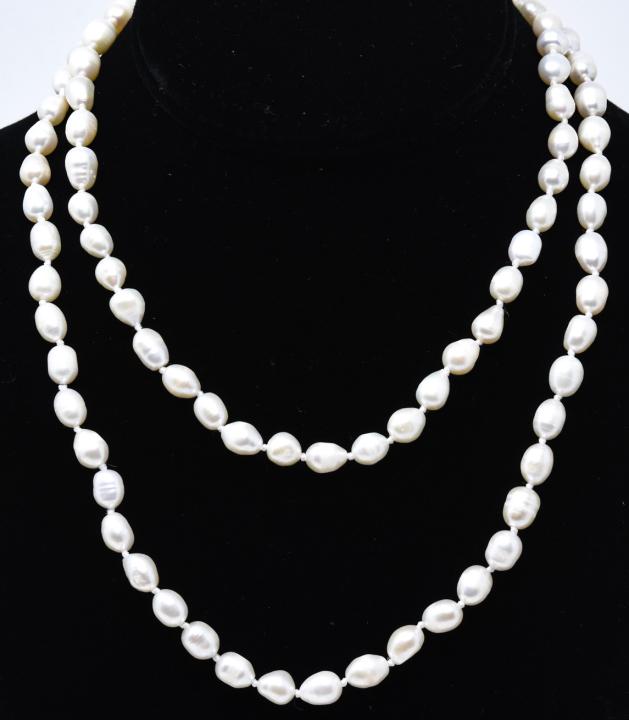 Hand Knotted Opera Length Baroque Pearl Necklace: Hand Knotted Opera Length Baroque Pearl Necklace Strand. Hand knotted on white silk thread with rose motif clasp. Measures 36 inches in length.