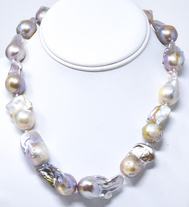 Graduated Size Cultured Baroque Pearl Necklace: Graduated Size Cultured Baroque Pearl Necklace. Hand knotted on silk thread. Large pearls with opalescent tones of gray, silver, pink and champagne. Largest measures 35 mm in length. Measures 18.5 inc