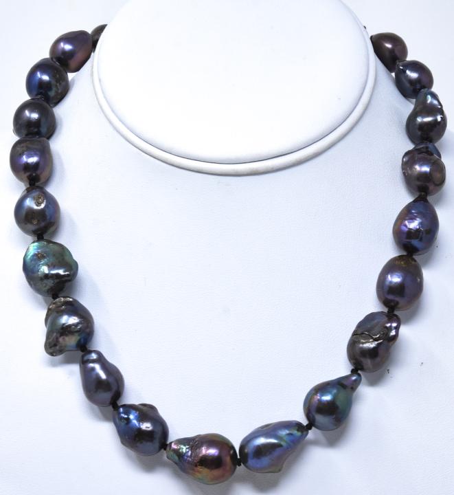 Cultured Black Tahitian Baroque Pearl Necklace: Cultured Black Tahitian Baroque Pearl Necklace Strand. Hand knotted on black silk thread. Graduated size pearls approximately 15 to 20 mm in length. Pearls with iridescent tones of black, silver and g
