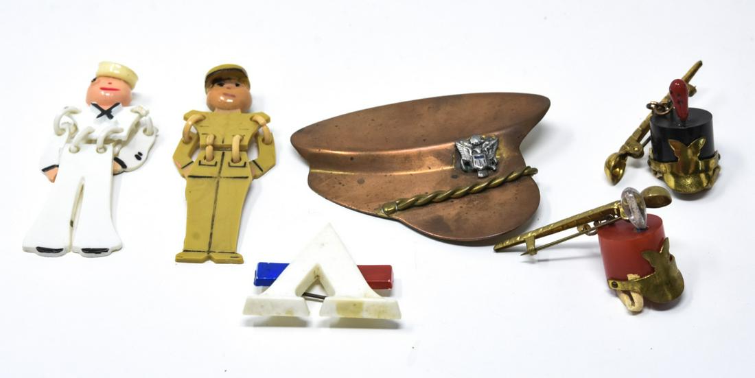 6 Military Theme Pins / Brooches Incl Bakelite: 6 Military Theme Pins / Brooches Incl Bakelite. Includes sailor, army, bakelite marching band headware, copper cap, and letter A or V. Copper cap measures just over 2 inches in length.