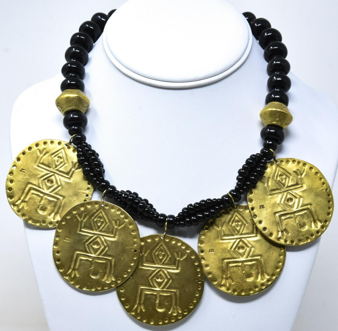 Black Coral Bead Tribal Design Necklace: Black Coral Bead Tribal Design Necklace. Necklace with possible black coral beads with hand wrought beads and hanging primitive design coins. Measures 17 inches.