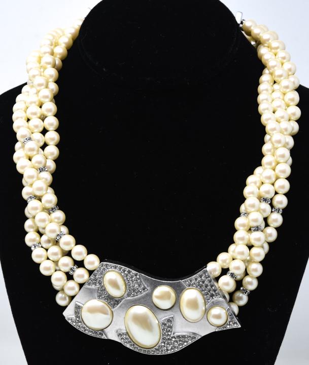 C 1980 Monet Statement Pearl Necklace: C 1980 Monet Statement Pearl Necklace. Four strands of 8mm costume pearls with large central plaque in white gold tone with pearls and clear paste stones. Measures 20 inches.
