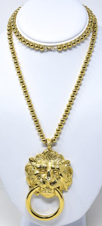 C 1980 Kenneth Lane Gilt Lion Doorknocker Necklace: C 1980 Kenneth Lane Gilt Lion Doorknocker Necklace. 29.5 inch bead strung chain with 3 7/8 inch detailed lion face doorknocker pendant. Signed Kenneth Lane on back of pendant.