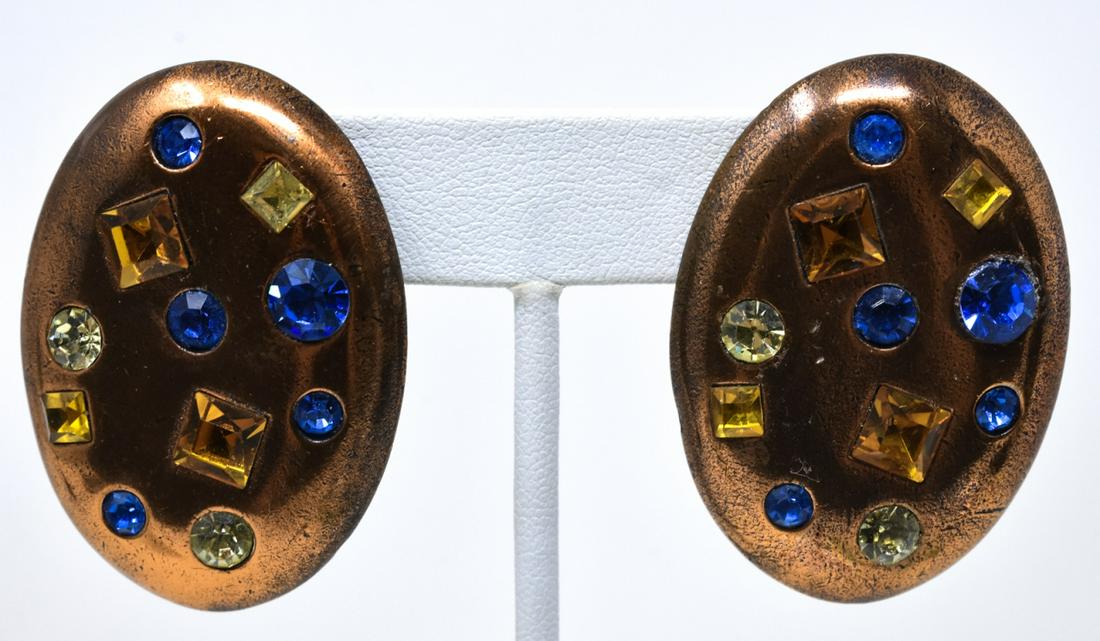 C 1990 Pair YSL Copper Oval Disc Clip Earrings: C 1990 Pair YSL Copper Oval Disc Clip Earrings. Each with round and square cut pastes in blue, yellow, jonquil, set in a copper oval disc. Each measures 1 3/4 inches. Signed.