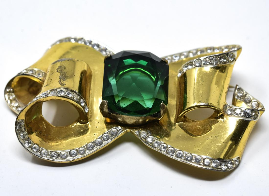Vintage Coro Craft Sterling & Emerald Paste Brooch: Vintage Coro Craft Sterling & Emerald Paste Brooch. Signed. Retro style. Gold over sterling silver ribbon motif. Measures 2.5 inches in length. Circa 1945, retro era.