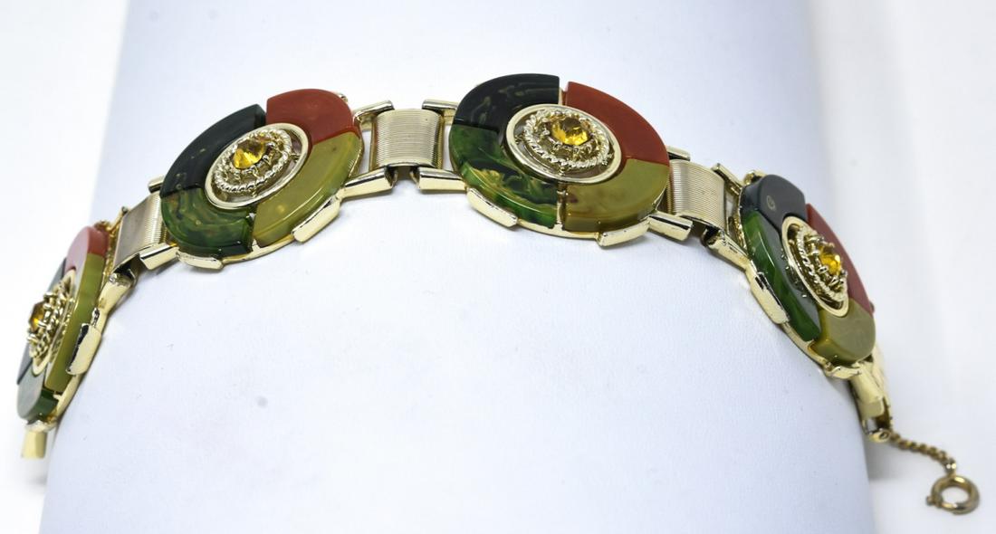 C 1950s Scottish Style Bakelite Bracelet: C 1950s Scottish Style Bakelite Bracelet. Featuring gilt ribbed bars between four multicolor marble arch bakelite segmented medallions with citrine paste center. Measures 7 inches.