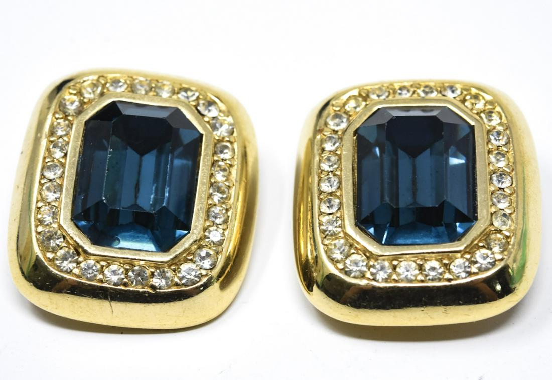 C 1960s Ciner Faux Sapphire Clip Earrings: C 1960s Ciner Faux Sapphire Clip Earrings. With large emerald cut faux sapphire center framed in gilt with clear paste halo. Each measures 1 1/4 inches.