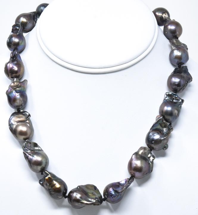 Black Tahitian Baroque Cultured Pearl Necklace: Hand Knotted Black Tahitian Baroque Cultured Pearl Necklace. Tones of gray, silver, champagne, black. Pearls vary in size slightly but are approximately 20 mm in length. Necklace measures 18 inches in