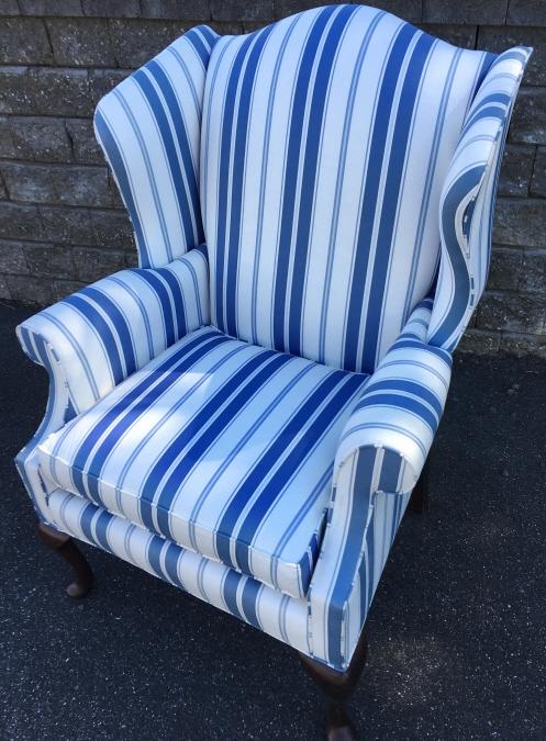 Oversized Custom Upholstered Wingback Arm Chair: Oversized Custom Upholstered Wingback Arm Chair. With cabriole legs, custom upholstered with blue and white striped fabric. Measures 43 inches x 31 inches x 30 inches.
