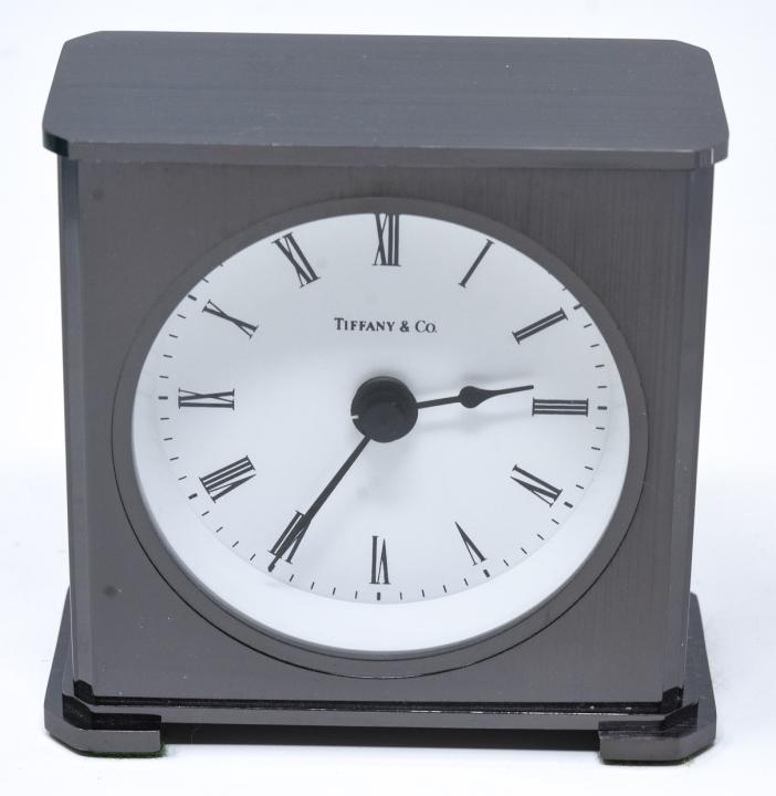 Tiffany & Co Gun Metal Tone Desk Clock: Tiffany & Co Gun Metal Tone Desk Clock. Gun metal toned desk clock by Tiffany & Co with original box and dust cloth. Measures 3 inches x 3 inches x 1.5 inches.