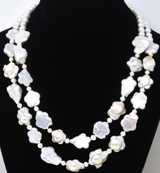Double Strand Hand Knotted Baroque Pearl Necklace: Double Strand Hand Knotted Baroque Pearl Necklace. Featuring oblong baroque pearls and floral form pearls. Longer strand measures 22 inches in length.