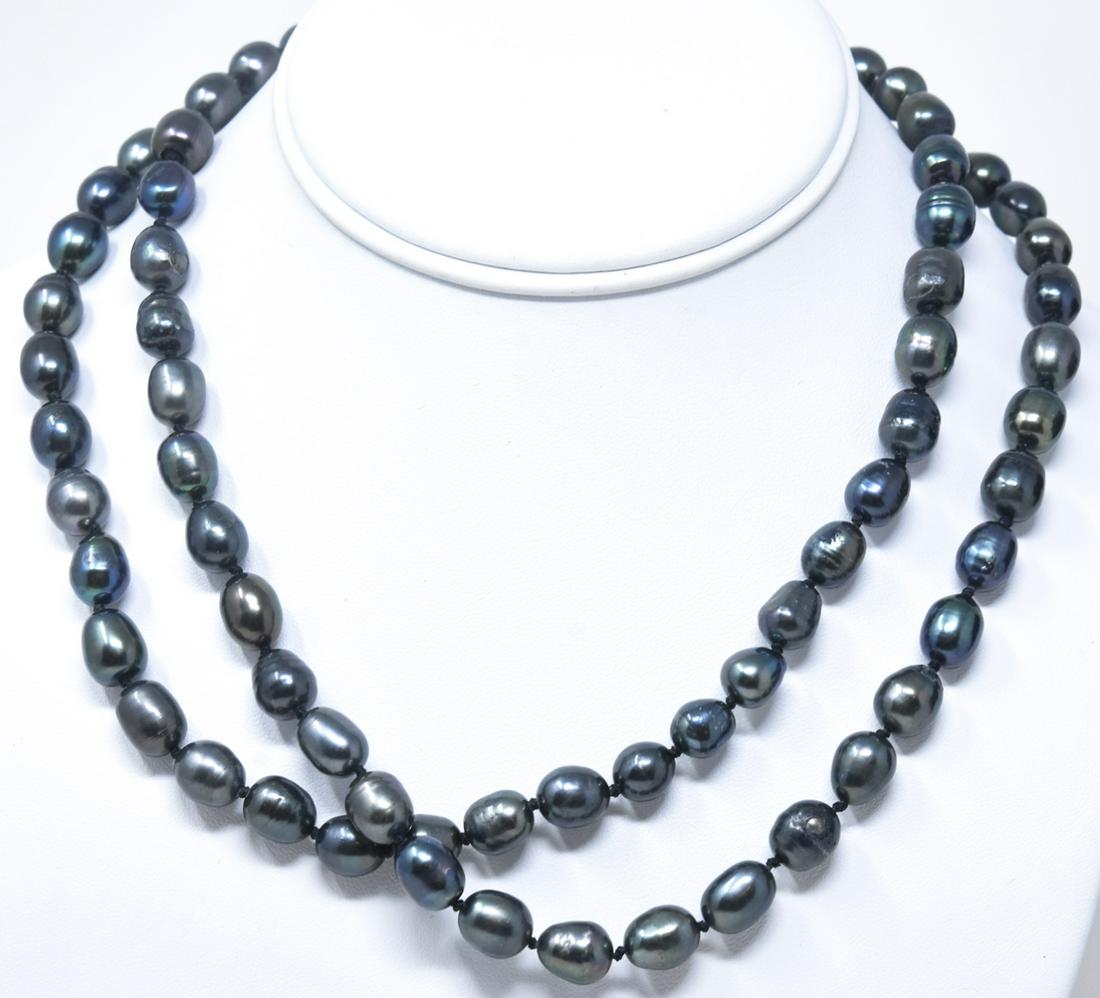 Pair of Cultured Tahitian Black Pearl Necklaces: Pair of Cultured Tahitian Black Pearl Necklaces. Hand knotted on black silk thread with tones of black, gray and silver. Filigree floral motif clasps. Each measures 18 inches in length.