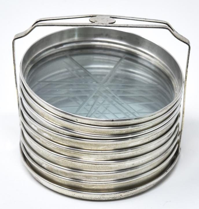 Set of Eight Sterling Silver & Cut Glass Coasters: Set of Eight Sterling Silver & Cut Glass Coasters on Fitted Stand. Starburst design. Each measures just over 3 inches in diameter.