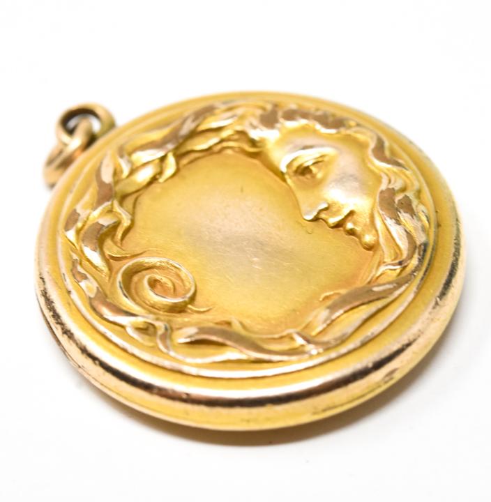 Antique C 1900 Art Nouveau Figural Locket Pendant: Antique C 1900 Art Nouveau Figural Locket Pendant. Gold filled / gold topped. Showing a lady's face in profile with flowing hair. Measures 1.5 inches in length with the bail.