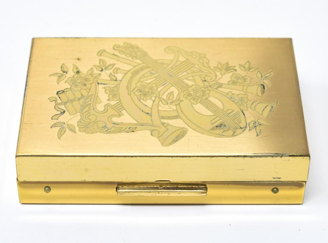 Vintage Elgin Music Box Makeup Compact: Vintage Elgin Music Box Makeup Compact. Gilt metal with musical instrument design on front. Comes with fitted black case. Measures 2 x 2.75 inches.