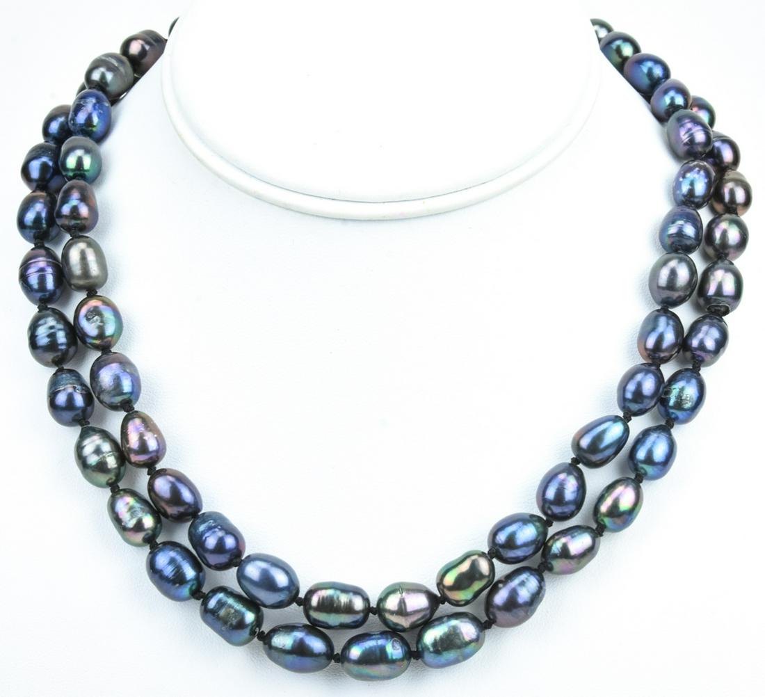 Pair of Cultured Tahitian Black Pearl Necklaces: Pair of Cultured Tahitian Black Pearl Necklaces. Hand knotted on black silk thread with tones of black, gray and silver. Filigree floral motif clasps. Each measures 18 inches in length.