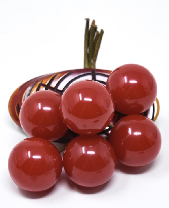 C 1945 Carved Bakelite "Wood" Slice Brooch: C 1945 Carved Bakelite "Wood" Slice Brooch. With red bunch of bakelite dangles. Measures 3 inches.