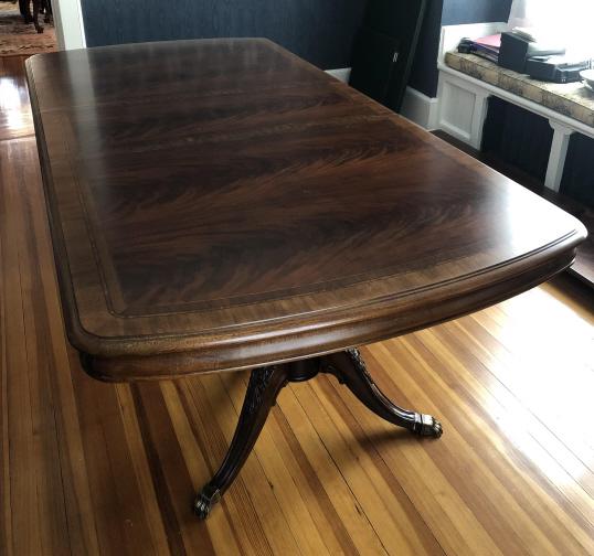 Thomasville Chippendale Double Pedestal Table: Thomasville Chippendale Double Pedestal Dining Table. Substantial dining table with carved double pedestal base and brass footed casters. Flame mahogany surface with fruit wood double banding. Table h