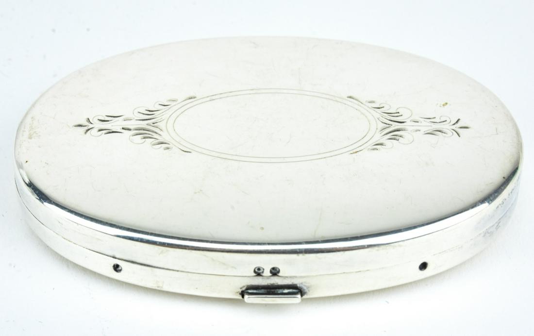 Antique Edwardian Sterling Silver Oval Compact: Antique Edwardian Sterling Silver Oval Compact. Chased Edwardian style design on top. Interior with mirror and lidded compartment for powder. Hallmarked STERLING. Measures 3.25 x 2.25 inches.
