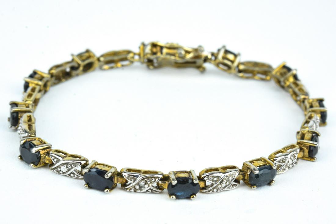 Estate Diamond & Blue Sapphire Tennis Bracelet: Estate Diamond & Blue Sapphire Tennis Bracelet. Set with three accent diamonds and twelve oval cut blue sapphires in gold plated sterling silver. Hallmarked. Two safety clasps. Measures 7.25 inches in