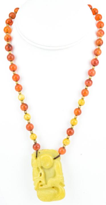 Estate Chinese Carnelian & Soapstone Necklace: Estate Chinese Carnelian & Soapstone Necklace. Beaded strand measures 18 inches in length, hand carved double sided pendant measures 2 inches in length.