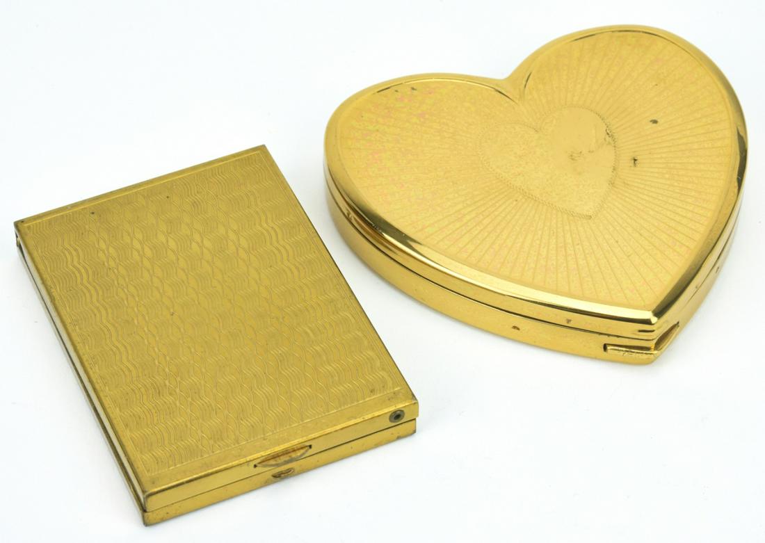 Two Vintage Mid Century Gilt Metal Compacts: Two Vintage Mid Century Gilt Metal Compacts. One heart shaped, one art deco style. Heart measures just under 3 inches in length.