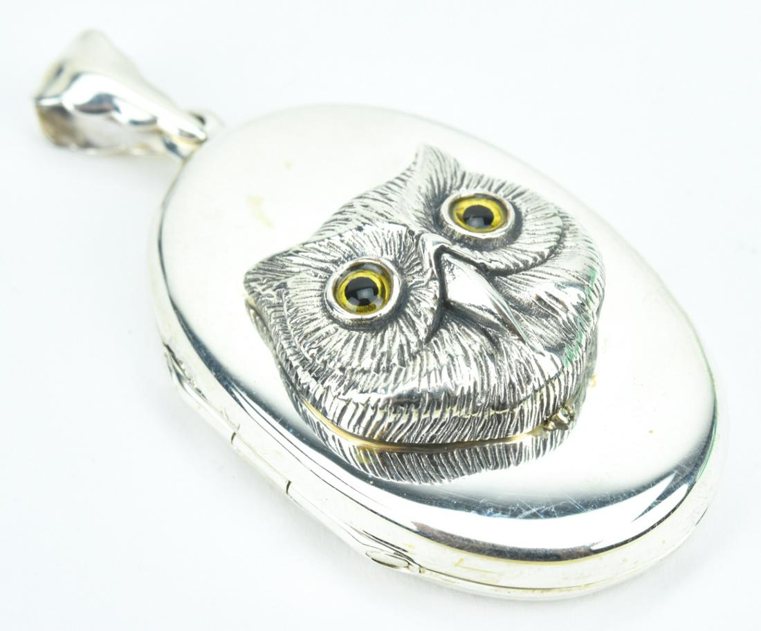 Sterling Silver Locket w Glassed Eyed Owl: Sterling Silver Locket w Glassed Eyed Owl. Engraved owl head with art glass eyes. Measures 2 inches in length.