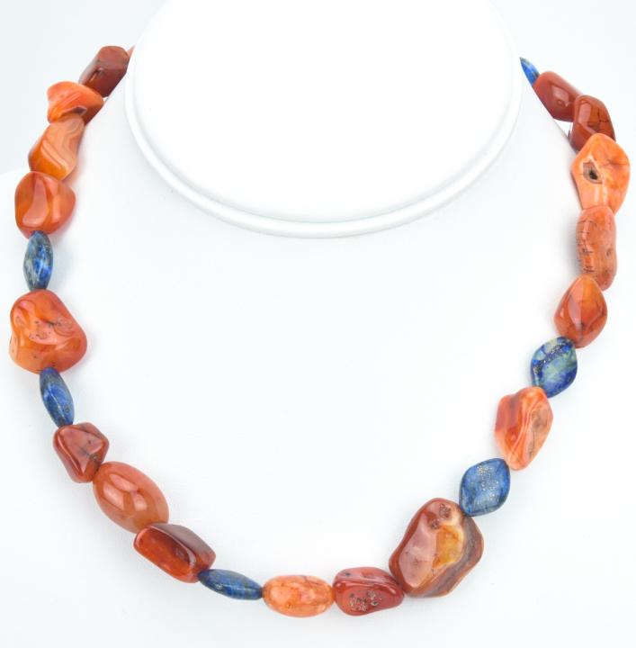 Handmade Carnelian & Lapis Lazuli Necklace: Handmade Carnelian & Lapis Lazuli Necklace. Featuring natural tumbled and carved stone beads. Measures 17.5 inches in length.
