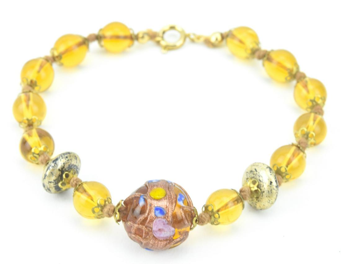 Vintage Italian Murano Art Glass Bracelet: Vintage Italian Murano Art Glass Bracelet. Citrine glass beads, accented with floral and gold fleck beads. Measures 7.75 inches in length.
