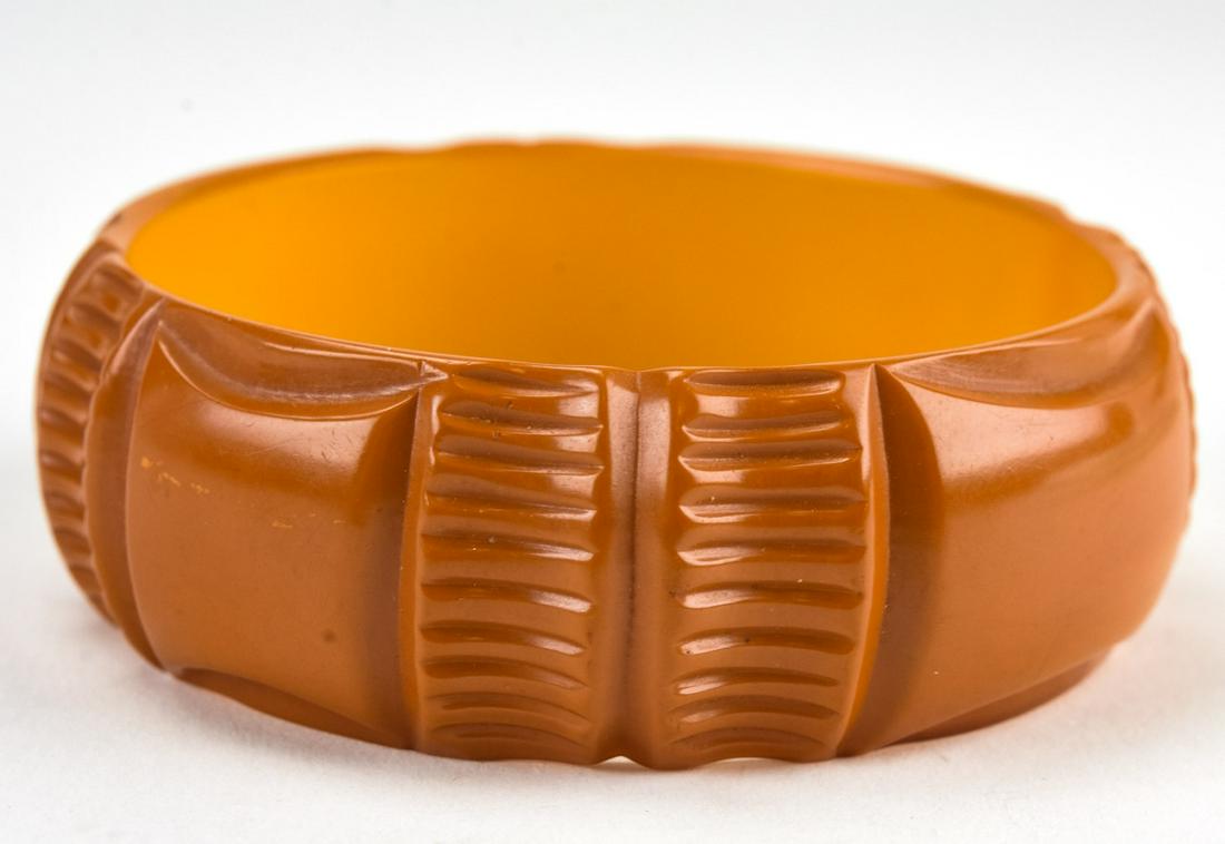 Wide Carved Amber Bakelite Bangle Bracelet: Wide Carved Amber Bakelite Bangle Bracelet. Measures 1 inch wide, 2.5 inches across the interior opening. Circa 1945.