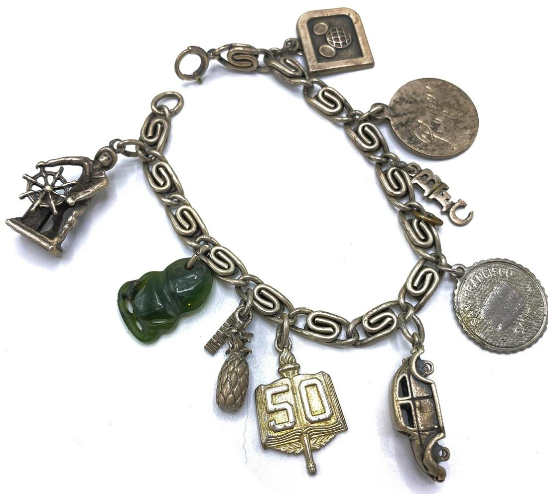 Vintage Sterling Silver Charm Bracelet: Vintage Sterling Silver Charm Bracelet – A vintage bracelet loaded with 9 charms that include a New England Fisherman, a Jade talisman, a Hawaiian pineapple, commemorative charm, a VW beetle, a San