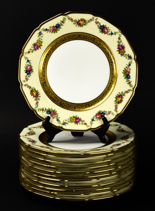 Set 12 Limoges Porcelain Scalloped Dinner Plates: Set 12 Limoges Porcelain Scalloped Dinner Plates. With gold tone banding and floral swag trim. Measures 11 inches in diameter.