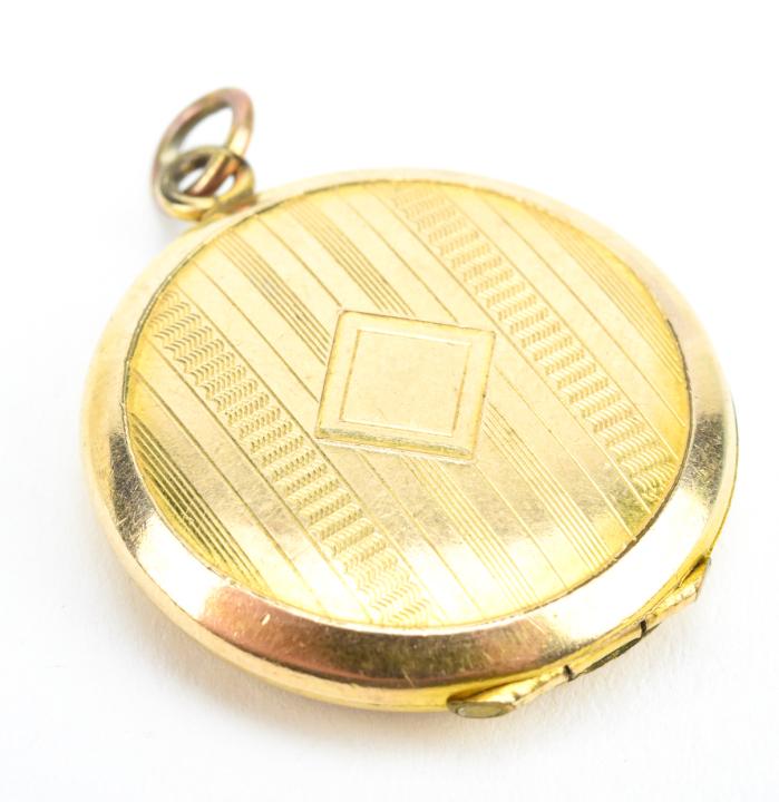 Antique Art Deco Striped Gold Locket: Antique Art Deco Striped Gold Locket. Round locket with striped textured finish on front, modeled in gold filled. Measures 1.25 inches in length plus bail.