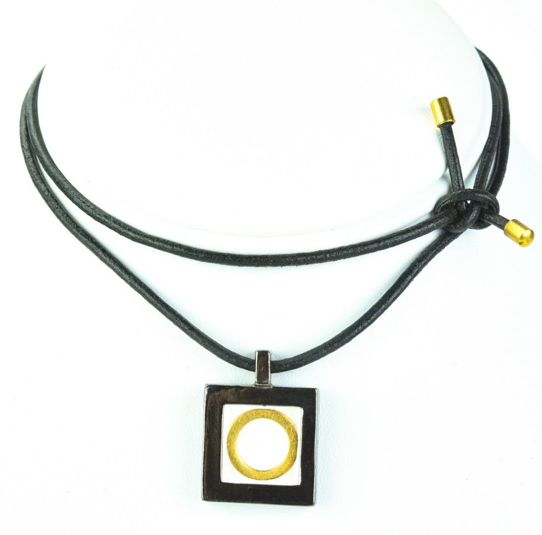 Vintage Karl Lagerfeld Enamel Pendant Necklace: Vintage Karl Lagerfeld Enamel Pendant Necklace. Silver and gold tone pendant with enamel on leather cord. Signed. Cord measures 22 inches in length.