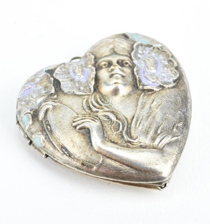 Vintage Art Nouveau Style Locket Pendant: Vintage Art Nouveau Style Locket Pendant. Heart shaped locket necklace pendant. Scene of woman playing tambourine surrounded by flowers. Measures 1.25 inches in length.