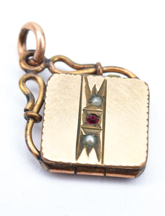 Antique 19th C Yellow Gold Locket Pendant: Antique 19th C Yellow Gold Locket Pendant. Front is set with two seed pearls and a garnet. Acid tests as 10kt. Measures just over 1 inch in length.
