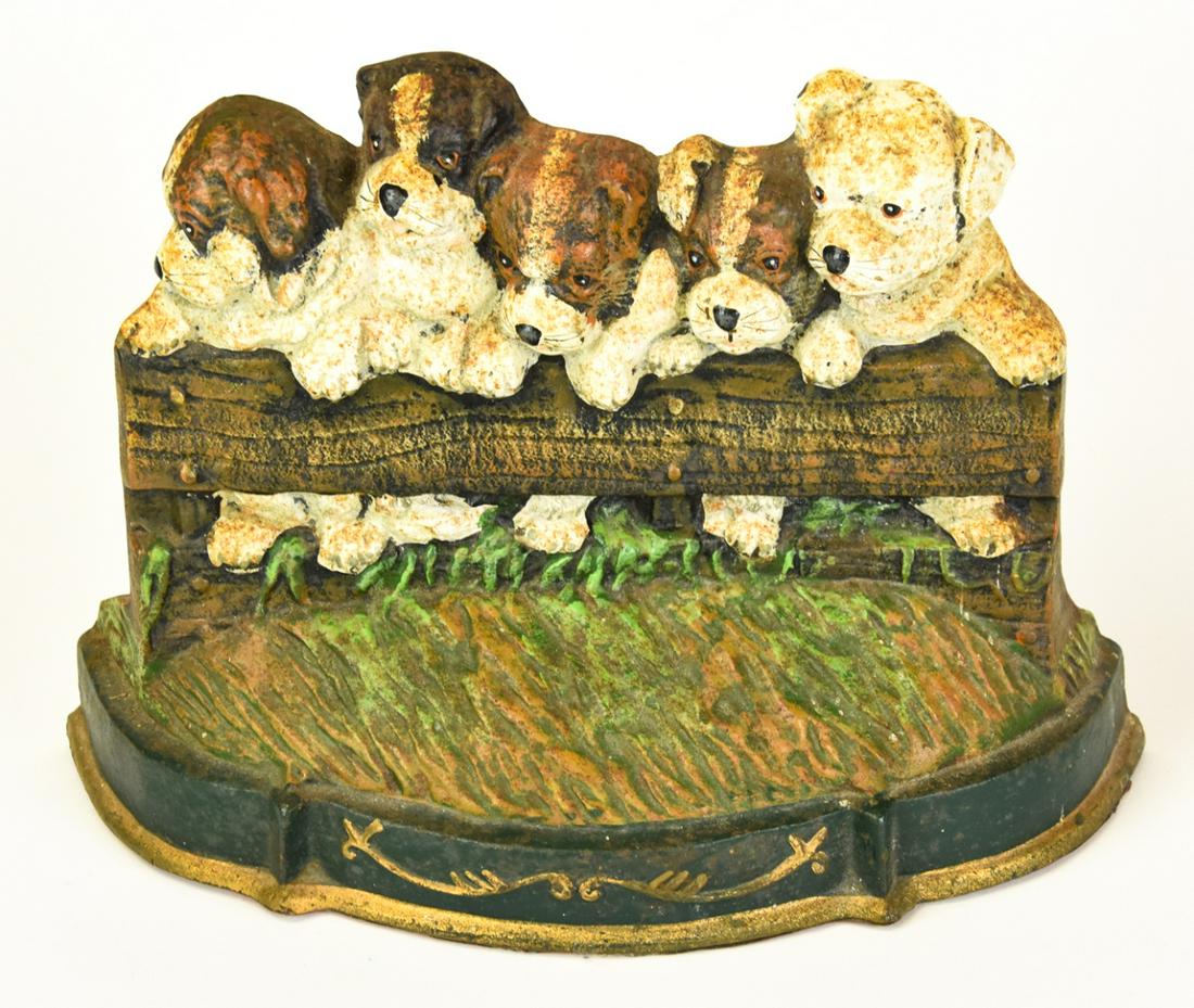 Painted Puppy Figural Door Stop: Painted Puppy Figural Door Stop. Scene of 5 hound dog puppies behind a fence. Measures 8 inches high by 11 inches wide by 3 inches deep.