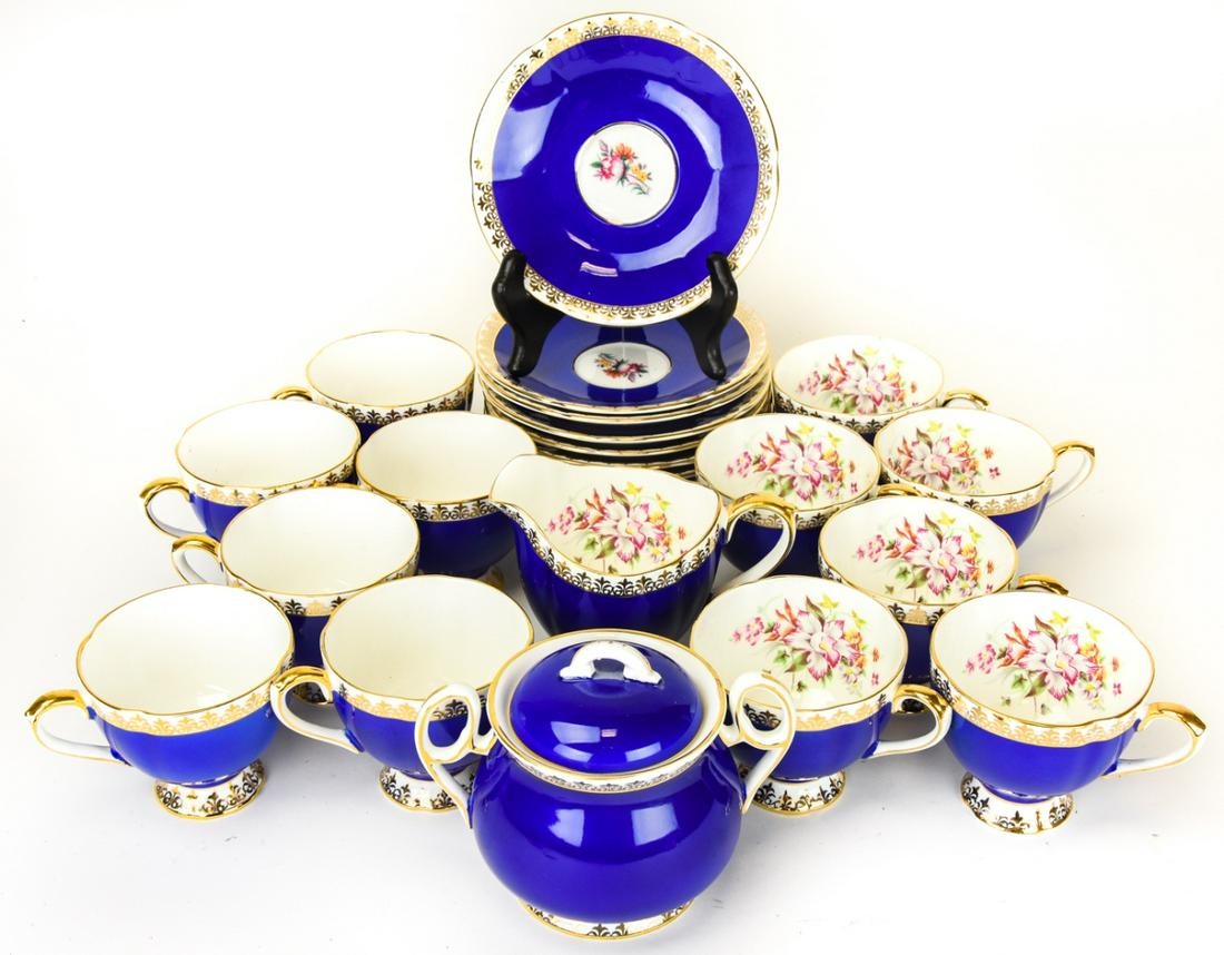 Taylor & Kent Bone China Partial Tea Set: Taylor & Kent Bone China Partial Tea Set. Includes 12 teacups, 12 saucers, lidded sugar bowl, and creamer. Teacup measures 3.25 inches in diameter.