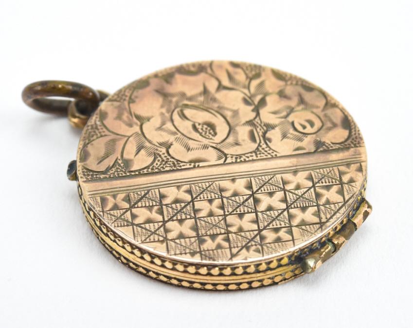 Antique 19th C Gold Floral Motif Locket Pendant: Antique 19th C Gold Floral Motif Locket Pendant. Chased floral design on the front and back. Tests as 10kt gold, may be gold panels front and back with gold filled frame. Measures 1.25 inches in lengt