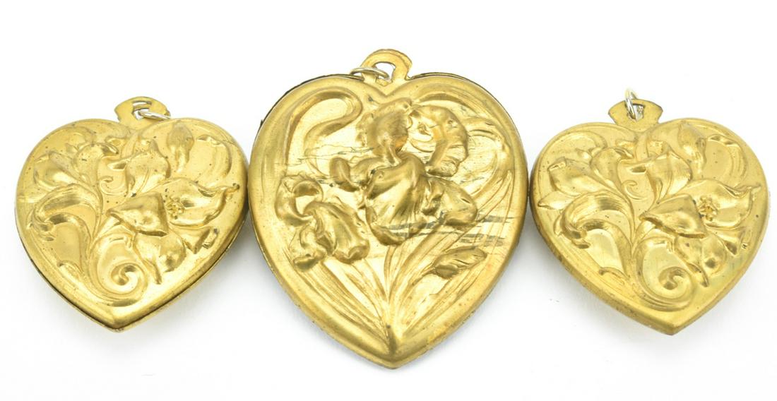 Three Antique Art Nouveau Heart Necklace Pendants: Three Antique Art Nouveau Heart Necklace Pendants. Each having Iris flower / lily flower design motifs. The largest measures 2.25 inches in length.