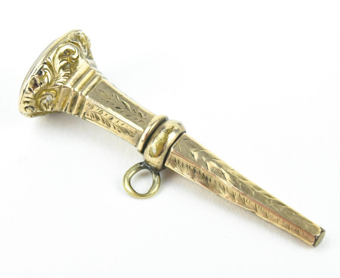 Antique 19th C English Georgian Gold Watch Key: Antique 19th C English Georgian Gold Watch Key Pendant / Fob Charm. Set with an agate plaque at the end. Low karat gold or cased gold. Measures nearly 1.75 inches in length.