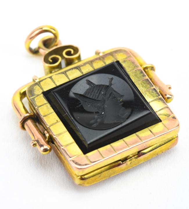 Antique 19th C Gold Onyx Carnelian Locket Pendant: Antique 19th C Gold Onyx Carnelian Locket Pendant. Front with Greco Roman style black onyx intaglio, back with solid carnelian plaque. Acid tests as 10kt gold, may be gold filled. Measures 1.5 inches 
