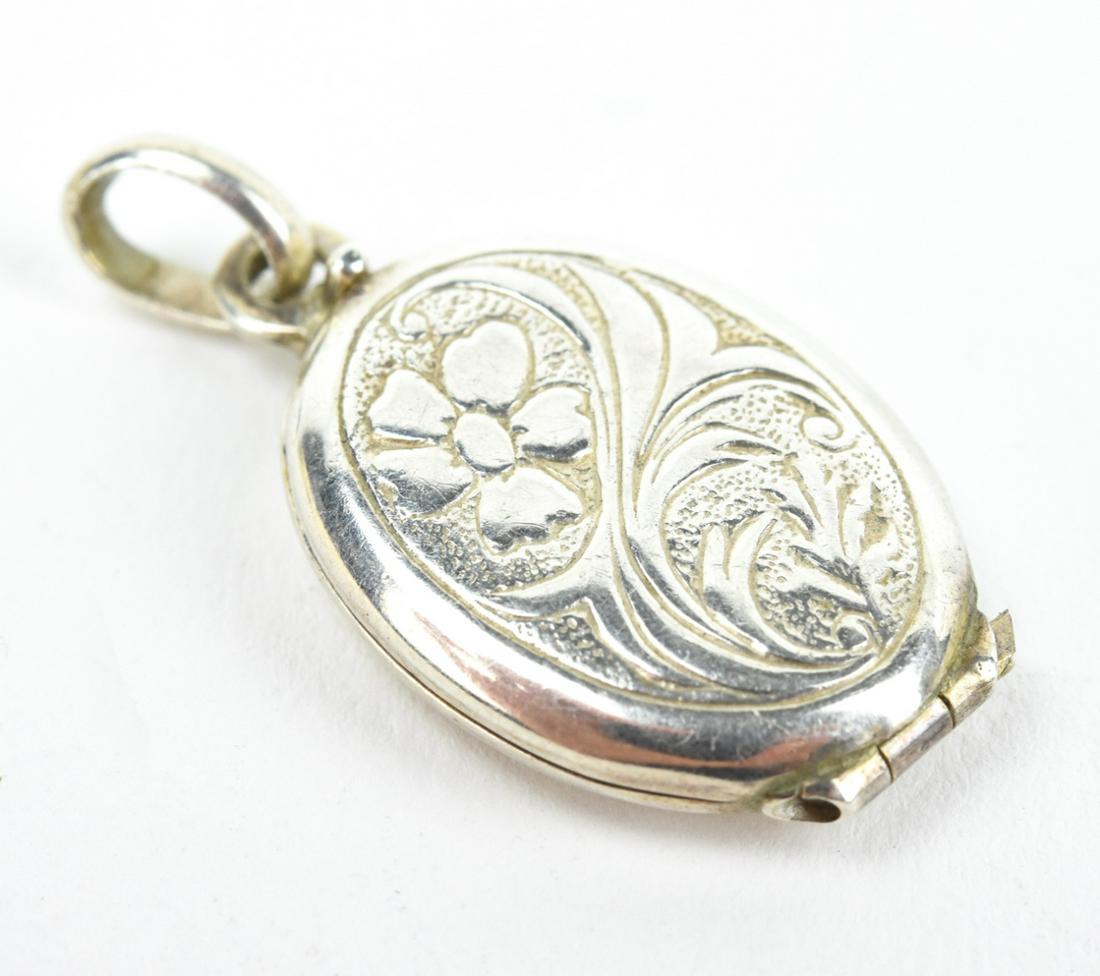 Estate Sterling Silver Oval Floral Motif Locket: Estate Sterling Silver Oval Floral Motif Locket Necklace Pendant. Floral and scrollwork motif. Measures 1.25 inches in length.