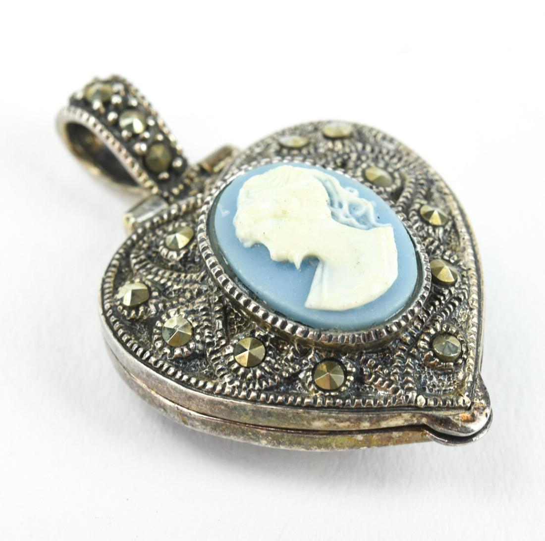 Sterling Silver Marcasite & Cameo Locket Pendant: Sterling Silver Rose Cut Marcasite & Cameo Locket Pendant. Heart form locket necklace pendant. Measures nearly 1.5 inches in length.