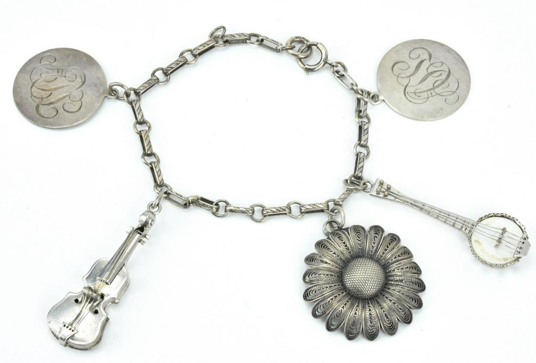 Vintage Sterling Silver Charm Bracelet: Vintage Sterling Silver Charm Bracelet. Including musical instruments, filigree, and monogrammed discs. Measures 7 inches in length.