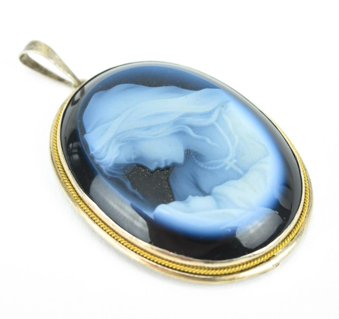 Estate Gold & Sterling Blue Agate Cameo Pendant: Estate Gold & Sterling Blue Agate Cameo Pendant. Necklace pendant with sterling mount and bail, gold rope halo, hand carved mother and child blue agate cameo. Measures just under 1.75 inches in length