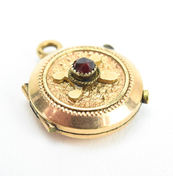 Antique 19th C 10kt Gold & Garnet Locket Pendant: Antique 19th C 10kt Gold & Garnet Locket Necklace Pendant. Acid tests as 10kt gold. Set with a garnet accent at center. Measures .75 of an inch in length.