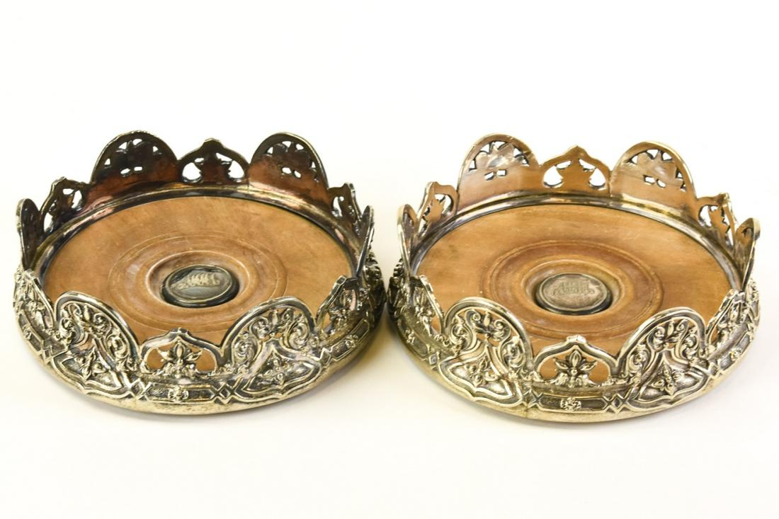 Pair Antique English Sterling Silver Wine Coasters: Pair Antique English Sterling & Silver Wine Coasters. Having silver plate galleries, wooden bottoms, and sterling silver medallions on bottom. Measures 6 inches in diameter.