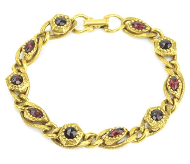 Vintage Costume Jewelry Goldette Garnet Bracelet: Vintage Costume Jewelry Goldette Garnet Bracelet. Articulated gilt metal panel bracelet set with rose cut garnet crystals. Measures 7.5 inches in length. Signed.